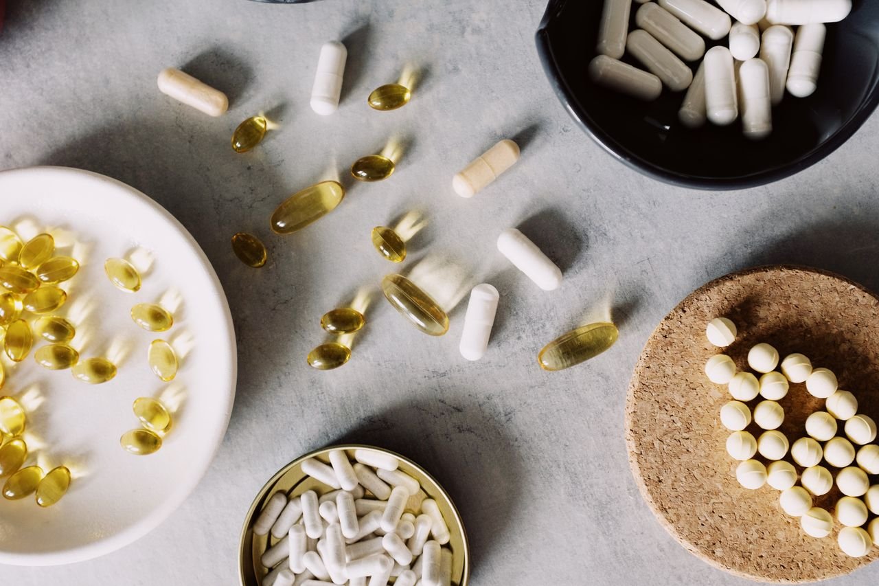 The Art of Drawing Readers In: Your attractive post title goes here Top view of omega on white plate capsules in black ceramic bowl dragees on cellulose stand antibiotics in metal container with vitamins in between on desk